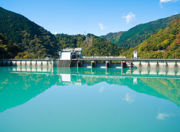 Scenic water reservoir dam surrounded by hills.