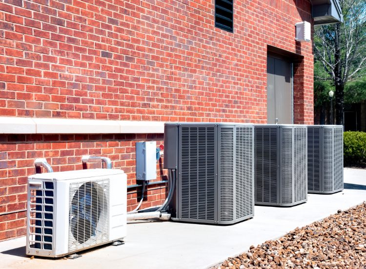 Air conditioning compressors on a walkway.